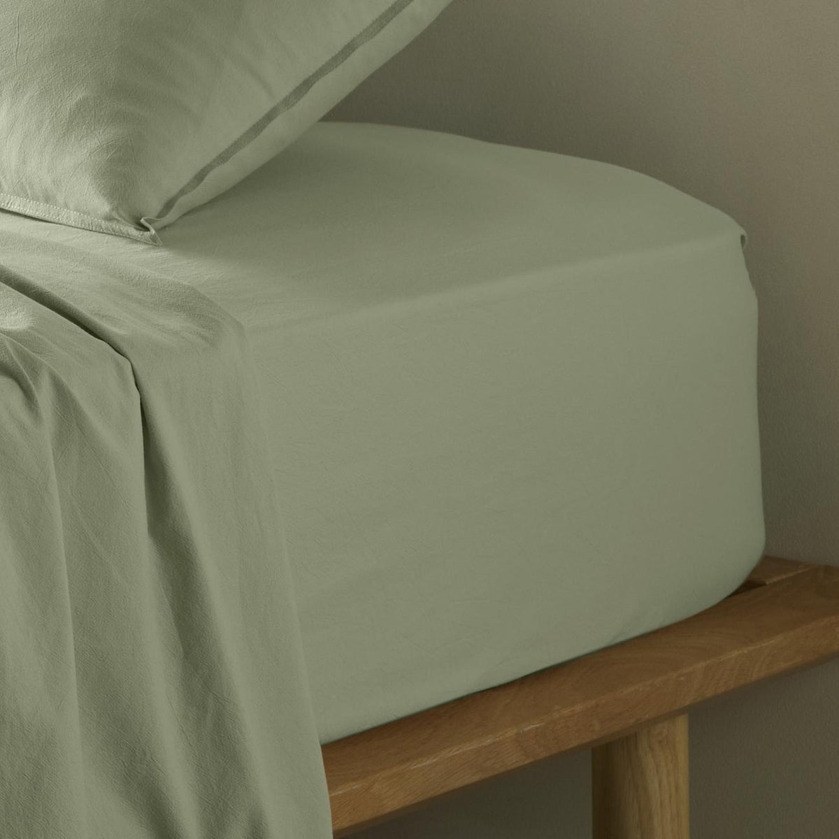 The Honest Label Washed Cotton Fitted Sheet in Sage with green tones fitted sheet close up detail