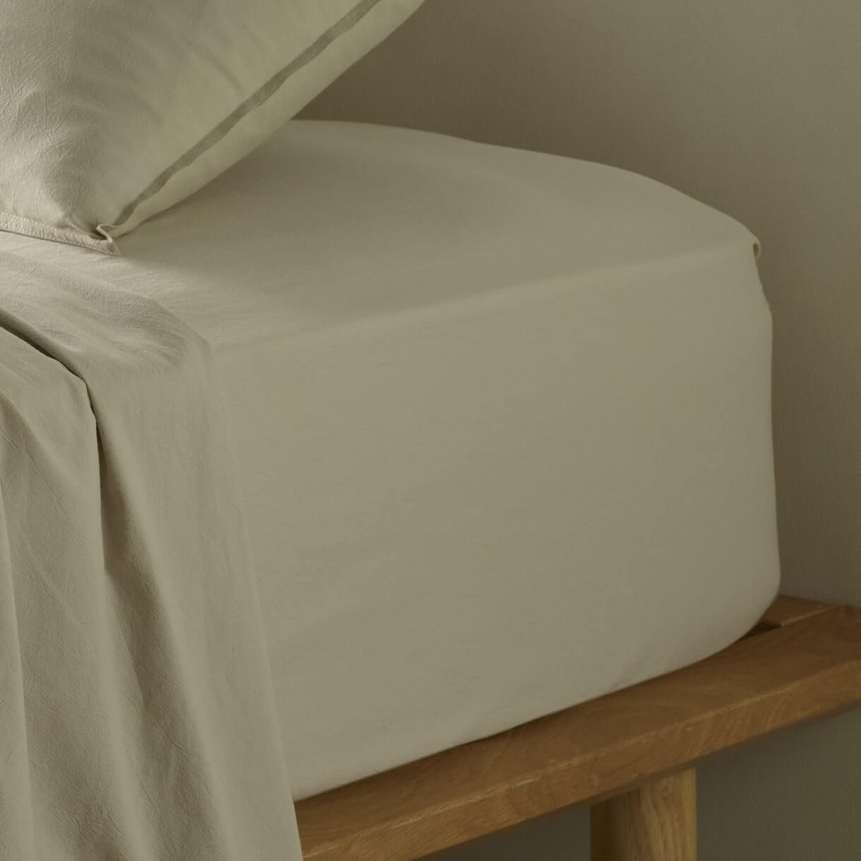 The Honest Label Washed Cotton Fitted Sheet in Flax with beige tones fitted sheet close up detail