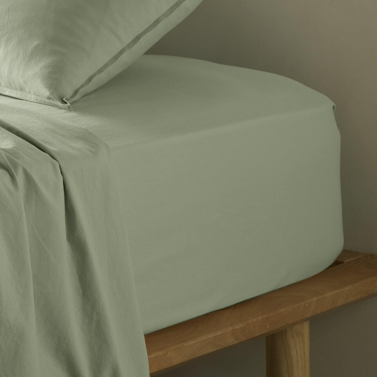 The Honest Label Washed Cotton Fitted Sheet in Sage with green tones fitted sheet close up detail