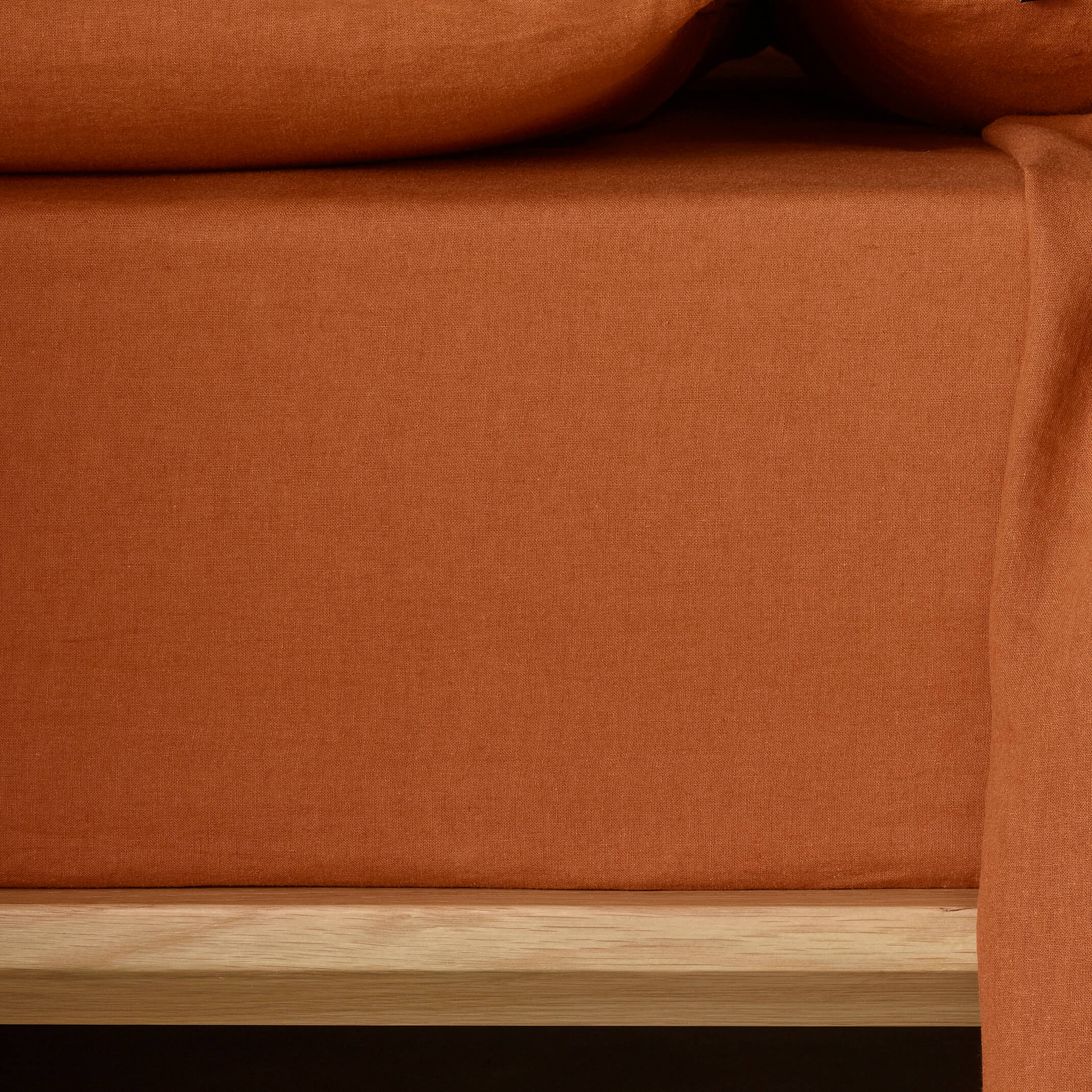 The Honest Label Pure Linen Fitted Sheet in Terracotta with red tones fitted sheet close up detail