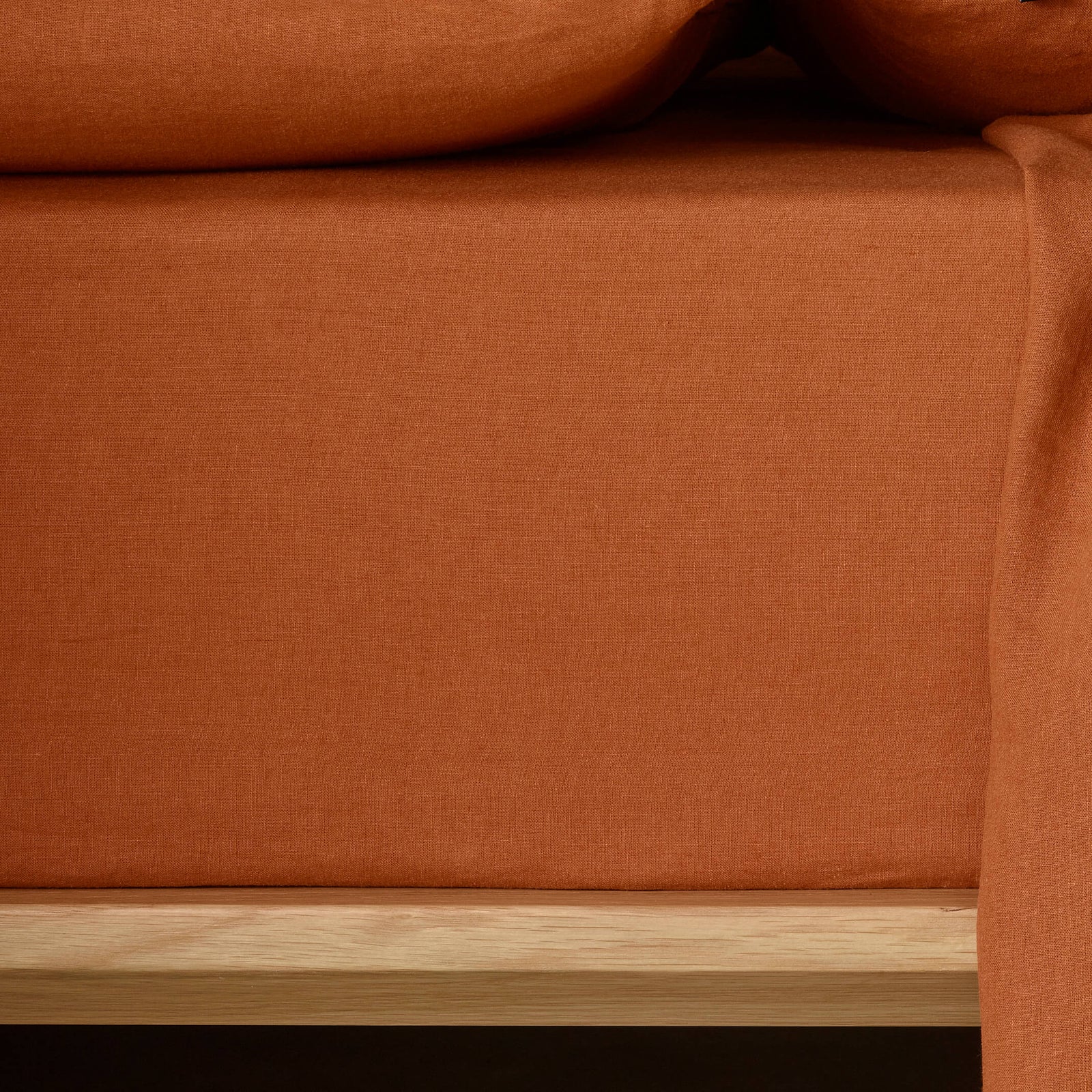 The Honest Label Pure Linen Fitted Sheet in Terracotta with red tones fitted sheet close up detail